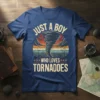 Just A Boy Who Loves Tornadoes text with a vintage tornado graphic and sunset background on a blue t-shirt