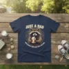 T-shirt design with text "JUST A DAD WHO ALWAYS CAME BACK WITH THE MILK" and a raccoon holding a milk