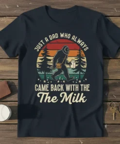 Retro Bigfoot graphic t-shirt with text "JUST A DAD WHO ALWAYS CAME BACK WITH THE The Milk" and sunset background
