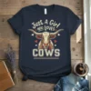Just A Girl WHO LOVES COWS text with longhorn cow graphic and red hearts on a navy t-shirt