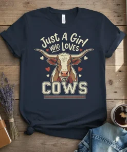 Just A Girl WHO LOVES COWS text with longhorn cow graphic and red hearts on a navy t-shirt