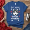 Blue t-shirt with "JUST A GIRL WHO LOVES HUSKIES" text and a graphic of a husky face surrounded by hearts