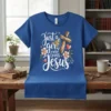 Blue t-shirt with white script text "Just a girl who loves Jesus" and a wooden cross graphic