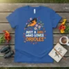 Blue t-shirt with the text "JUST A GIRL WHO LOVES ORIOLES" and an illustration of an oriole bird perched on