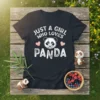 Black t-shirt with white text "JUST A GIRL WHO LOVES PANDA" and a geometric panda face graphic