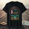 Black t-shirt featuring text "JUST A New Jersey Girl Cersey IN A South Carolina WORLD" with map outlines of New