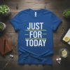 Blue t-shirt with white text "JUST FOR TODAY" in three lines, separated by yellow horizontal lines. Motivational quote design