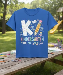 K Is For Kindergarten text with educational graphics like books, pencils, and globes on a blue t-shirt