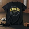 Black t-shirt with "Karate Mama" in gold varsity font, featuring a karate kick graphic and Japanese characters