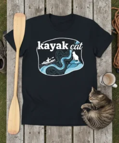 Black t-shirt with white text "kayak cat" above a graphic of a person kayaking down a river with a cat