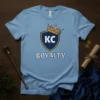 KC Royalty t-shirt design with a blue shield, gold crown, and "KC" text, plus "ROYALTY" text below