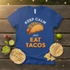 Keep Calm And Eat Tacos text with a detailed taco graphic on a royal blue t-shirt