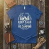 Keep Calm and Go Camping quote on a blue t-shirt, featuring a tent, trees, moon, and wreath graphic