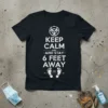 Black t-shirt with white text "KEEP CALM AND STAY 6 FEET AWAY" and footprints graphic, includes biohazard symbol