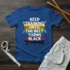 Keep Training Until The Belt Turns Black T-Shirt featuring colorful martial arts belts and a black belt graphic