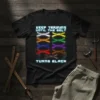 Black t-shirt with blue neon text "KEEP TRAINING UNTIL THE BELT TURNS BLACK" and a graphic of colored martial arts