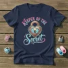 Keeper of the Secret t-shirt design with heart-shaped lock and baby footprints graphic