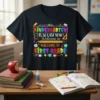 Black t-shirt with colorful "Kindergarten Is So Last Year Welcome To First Grade" text and school-themed graphics