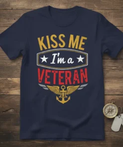 Navy blue t-shirt with "KISS ME I'm a VETERAN" text in yellow and red, featuring an anchor and wings graphic