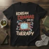 Korean Dramas Are My Therapy text on a black t-shirt with a vintage TV graphic and cherry blossoms