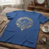 Blue t-shirt with "La-di-da" in a golden, ornate circular design with floral elements and hearts