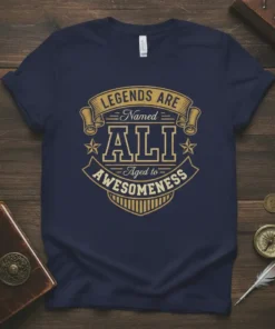 Legends Are Named Ali Aged to Awesomeness text design on a navy blue t-shirt, featuring golden typography and a vintage