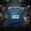 Let's Cook t-shirt design featuring a beaker and whisk, with bold green and white text
