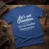 Blue t-shirt with white text: "Let's eat Grandma. Let's eat, Grandma. Commas save lives" highlighting grammar importance
