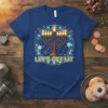 Blue t-shirt with "Let's Get Lit" text and a glowing menorah design, symbolizing Hanukkah celebrations