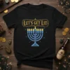 Black t-shirt with "LET'S GET LIT" text above a glowing neon blue menorah for Hanukkah celebrations