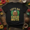 Let's Go Coco Nuts text with a smiling coconut wearing a flower crown on a black t-shirt, tropical design