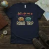 Navy t-shirt with "let's go on a ROAD TRIP" text and two colorful camper illustrations, primary keyword included