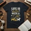 Life Is Better With A Dog quote with paw prints and dog graphics on a dark t-shirt