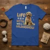 Goldendoodle dog sitting with text "Life Is Better With A Goldendoodle" on a royal blue t-shirt