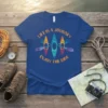 Blue t-shirt with orange text "LIFE IS A JOURNEY ENJOY THE RIDE" and three colorful kayaks with paddles graphic