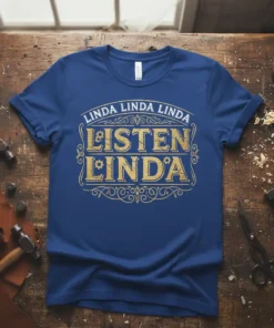 Blue t-shirt with gold text "Linda Linda Linda LISTEN LINDA" in decorative font, featuring gears and swirls