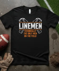 Black t-shirt with white and orange text "LINEMEN TECHNICALLY THE ONLY MEN ON THE FIELD" and football helmet graphics