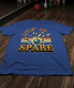 Livin' On Spare bowling quote t-shirt with retro sunset stripes and bowling ball striking pins