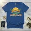 Blue t-shirt with "LIVING LIFE ONE CRUISE AT A TIME" text and a cruise ship sailing at sunset with palm