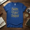 Blue t-shirt with gold glitter text "love like Jesus" and a cross graphic