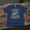 Navy blue t-shirt with distressed gold text "LUCKY SHIRT FISHING DO NOT WASH" and a graphic of a bass fish