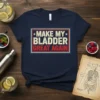 Make My Bladder Great Again text in distressed red, white, and blue design on a navy t-shirt