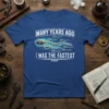 "Many Years Ago I Was The Fastest" text design with sperm graphic on a blue t-shirt, humorously referencing dad's past