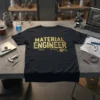 Material Engineer text design with circuit board elements and gear graphic on a black t-shirt