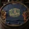 May Contain Whiskey t-shirt design with gold lettering and oak leaf accents, featuring a glass of whiskey