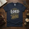 Navy blue t-shirt with "May the Lord Be With You" in decorative white and gold lettering, Christian apparel design