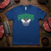 MEAT SWEATS text design with crossed cleavers over a grill graphic, on a blue t-shirt