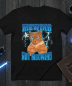 Funny "MEWING NOT MEOWING" text with a ginger cat and lightning graphic on a black t-shirt