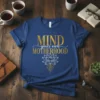 Mind Your Own Motherhood quote t-shirt with lotus flower graphic in gold and white on a navy blue tee