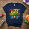 Mommy Of The Birthday Boy text with pixelated design and firefighter helmet graphic on a navy blue t-shirt